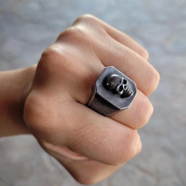 Homme portant une Chevalière Tête de Mort en Acier Inox Noir Vintage Homme portant une Chevalière Tête de Mort en Acier Inox Noir Vintage.