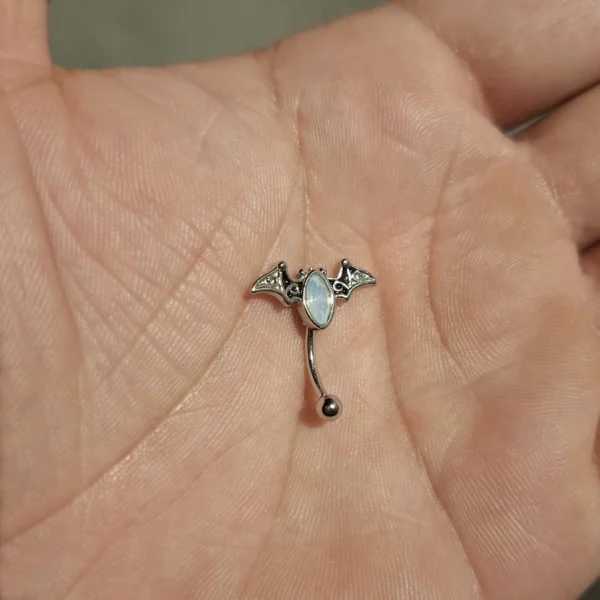 Piercing Arcade Chauve-Souris Ornée d’une Opalite aux Reflets Lunaires Piercing Arcade Chauve-Souris Ornée d’une Opalite aux Reflets Lunaires.