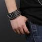 Homme avec un Bracelet clouté en cuir véritable à 4 rangées de clous.