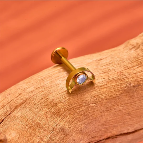 Piercing Labret Titane ASTM-F136 de couleur Doré Anodisé en forme de Croissant de Lune Ajouré à Zircon Serti Piercing Labret Titane ASTM-F136 de couleur Doré Anodisé en forme de Croissant de Lune Ajouré à Zircon Serti.