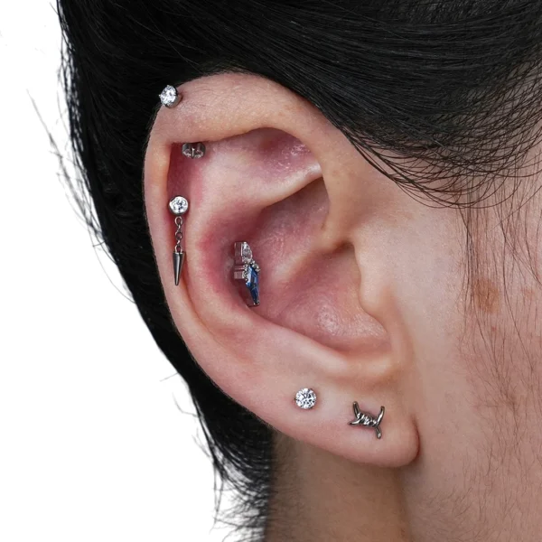 Femme Punk avec un Piercing Labret Titane à Zircon Serti & Spike Suspendu sur l'Hélix (cartilage) Femme Punk avec un Piercing Labret Titane à Zircon Serti & Spike Suspendu sur l'Hélix (cartilage).