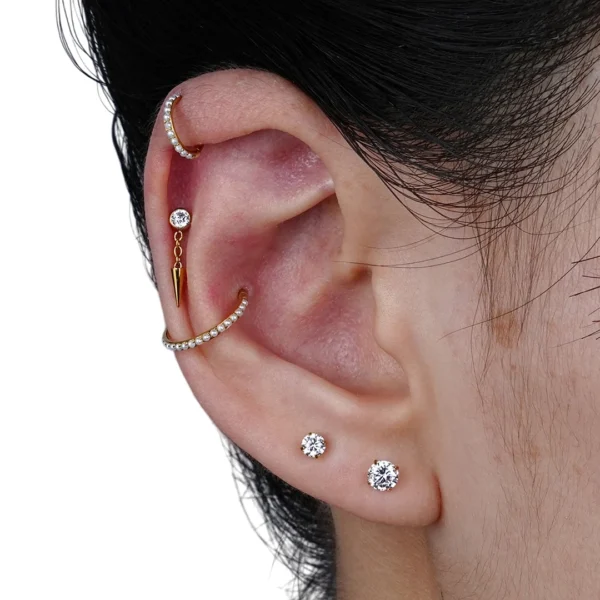 Femme portant un Piercing Labret Titane Zircon Serti & Spike Suspendu à l'Hélix Femme portant un Piercing Labret Titane Zircon Serti & Spike Suspendu à l'Hélix.