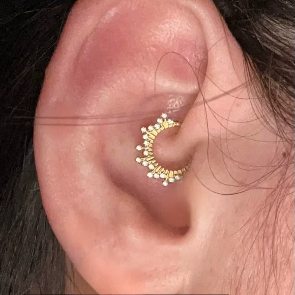 Femme avec un Anneau de Piercing Clicker en Titane à Frise Lumineuse au Cartilage Femme avec un Anneau de Piercing Clicker en Titane à Frise Lumineuse au Cartilage.
