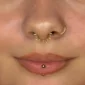 Femme avec un Piercing Anneau Clicker Chaîne Maillons à Pointes Fines au Septum.