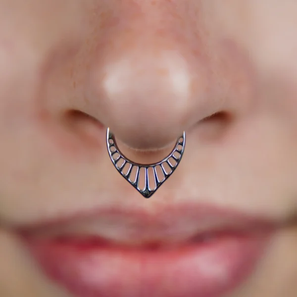 Femme avec un Piercing Anneau Clicker en V Ajouré au Septum Femme avec un Piercing Anneau Clicker en V Ajouré au Septum.