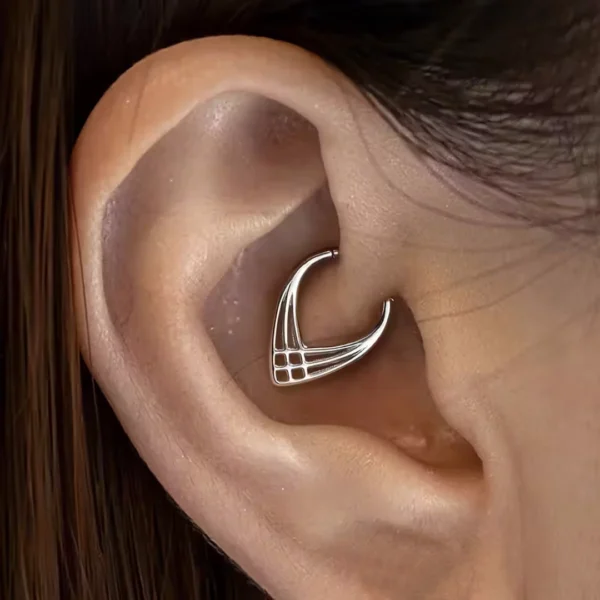 Femme avec un Piercing Clicker Ajouré à Chevrons Croisés au Daith Femme avec un Piercing Clicker Ajouré à Chevrons Croisés au Daith.