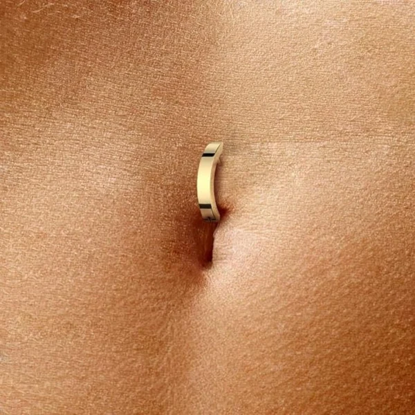 Femme avec un Piercing Nombril Anneau Clicker en Titane Anodisé Doré Femme avec un Piercing Nombril Anneau Clicker en Titane Anodisé Doré.