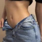 Femme avec un Piercing Nombril Clicker Titane Anodisé Doré à Barrette Sertie Zircons