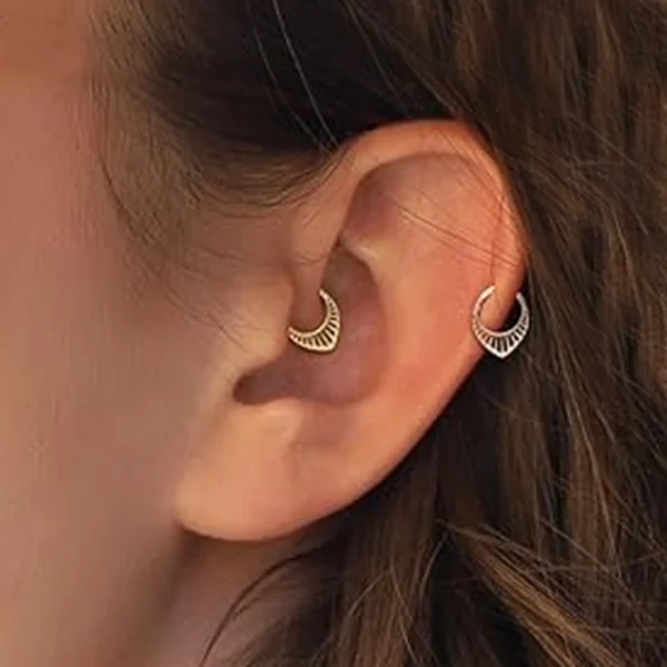 Femme portant un Piercing Anneau Clicker en V Ajouré au Daith et à l'Hélix Femme portant un Piercing Anneau Clicker en V Ajouré au Daith et à l'Hélix.