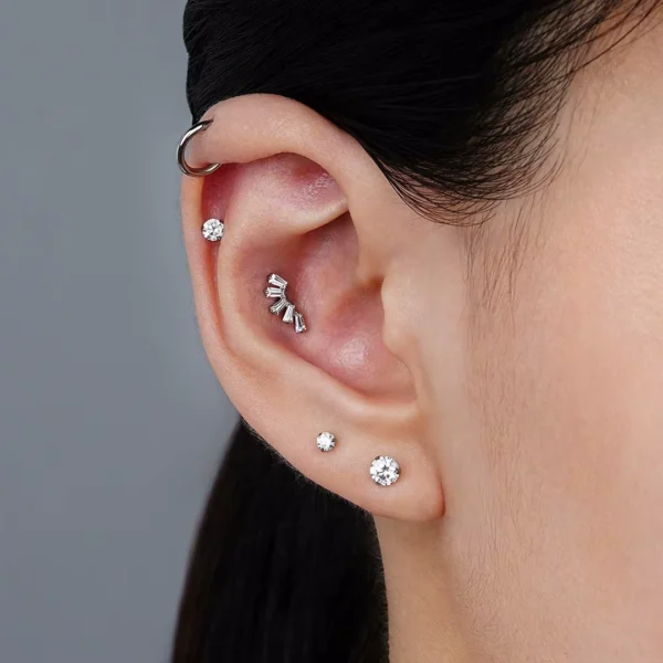 Femme portant un Piercing Labret Éventail Baguettes Zircons en Titane au Conch Interne Femme portant un Piercing Labret Éventail Baguettes Zircons en Titane au Conch Interne.