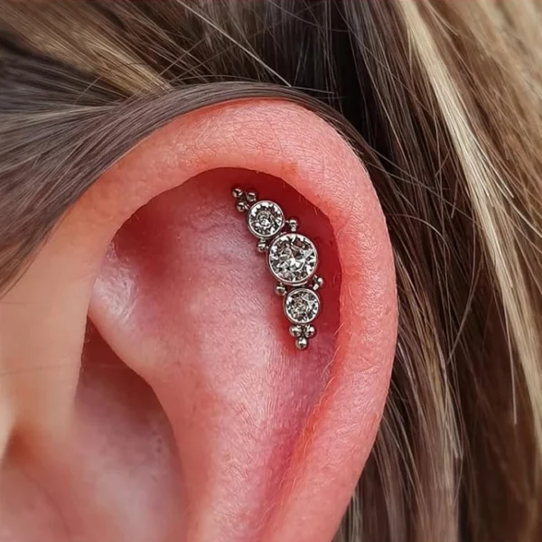 Femme portant un Piercing Labret Titane Harmonie de Zircons & Billes à l'Hélix (cartilage) Femme portant un Piercing Labret Titane Harmonie de Zircons & Billes à l'Hélix (cartilage).