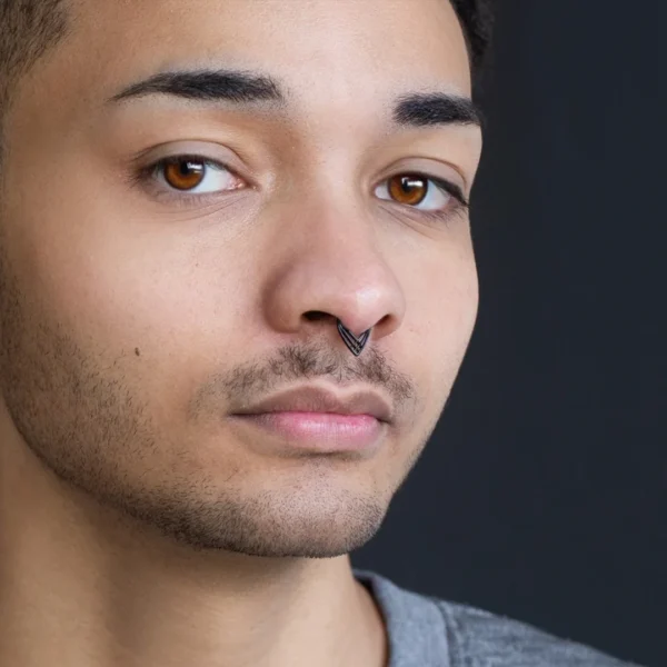 Homme portant un Piercing Clicker Ajouré à Chevrons Croisés au Septum Homme portant un Piercing Clicker Ajouré à Chevrons Croisés au Septum.