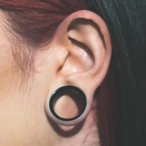 Femme avec un Écarteur Tunnel Acier 316L Double Évasé & Dévissable au Lobe (oreille).