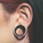Femme avec un Écarteur Tunnel Acier 316L Double Évasé & Dévissable au Lobe (oreille).