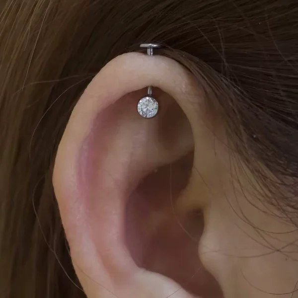 Femme avec un Piercing Labret Titane à Filetage Interne Latéral sur l'Hélix Femme avec un Piercing Labret Titane à Filetage Interne Latéral sur l'Hélix.