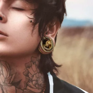 Homme portant un Écarteur Tunnel Serpent Cobra en Acier 316L Doré PVD.
