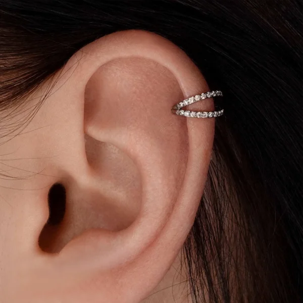 Femme avec Piercing Double Anneau Zirconiums Titane Clicker Ø 8 mm à l'Hélix Femme avec Piercing Double Anneau Zirconiums Titane Clicker Ø 8 mm à l'Hélix.