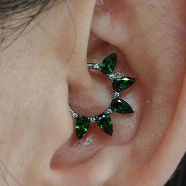 Femme avec Clicker Titane à 5 Marquises de Zirconiums Émeraude au Daith (cartilage oreille) Femme avec Clicker Titane à 5 Marquises de Zirconiums Émeraude au Daith (cartilage oreille).