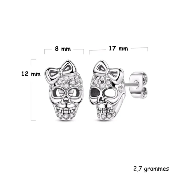 Boucles d’oreilles Tête de Mort Pavée de Zircons avec Nœud (dimensions) Boucles d’oreilles Tête de Mort Pavée de Zircons avec Nœud (dimensions).