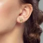 Femme avec Boucles d'oreilles Crâne Doré Pavé de Zircons en Argent 925 au Lobe.