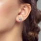 Femme avec Boucles d’oreilles Tête de Mort Pavée de Zircons avec Nœud au Lobe.