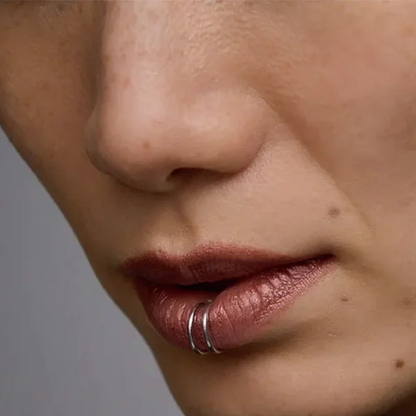 Femme avec Faux Piercing Lèvre Double Anneau Acier 316L au Labret Vertical Femme avec Faux Piercing Lèvre Double Anneau Acier 316L au Labret Vertical.