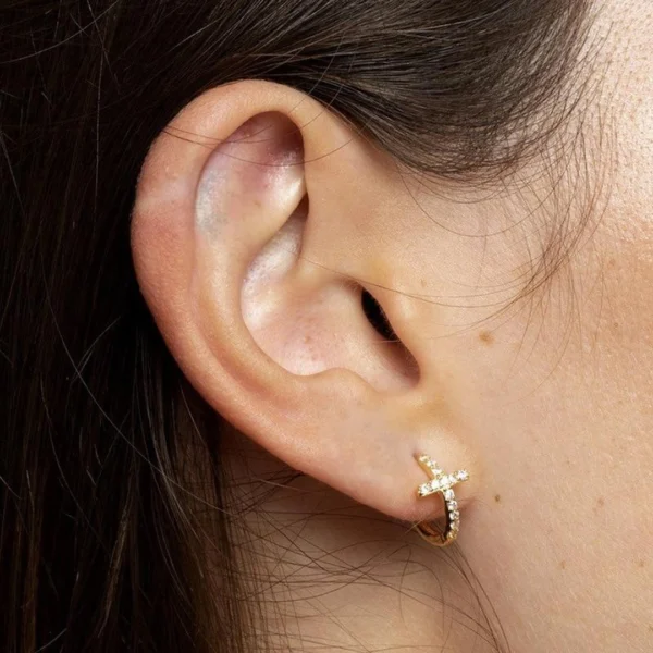 Femme avec Piercing Anneau Clicker Titane Croix Pavée de Zircons au Lobe d'Oreille Femme avec Piercing Anneau Clicker Titane Croix Pavée de Zircons au Lobe d'Oreille.