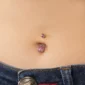 Femme avec Piercing Nombril à Boules Serties Zirconiums Rose Vif en Acier 316L.