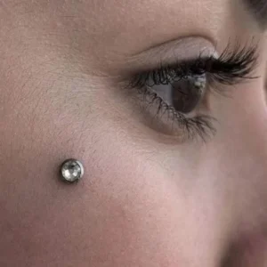 Femme avec Piercing de Surface en Titane Microdermal & Zircon au Visage Femme avec Piercing de Surface en Titane Microdermal & Zircon au Visage.