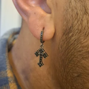 Homme avec Créoles Pendantes Croix Gothique Pavée de Zirconiums Noirs.