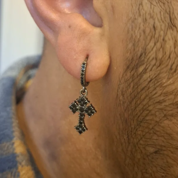 Homme avec Créoles Pendantes Croix Gothique Pavée de Zirconiums Noirs Homme avec Créoles Pendantes Croix Gothique Pavée de Zirconiums Noirs.