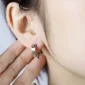 Femme avec Boucles d’Oreilles Anneaux à Pointes Clicker Acier 316L au Lobe.