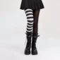 Femme avec Collants Asymétriques Rayés Noir et Blanc.