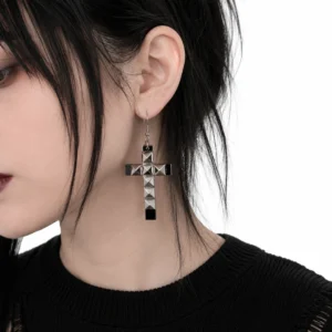 Femme Gothique avec Boucles d'Oreilles Croix Rivetée Pyramide.
