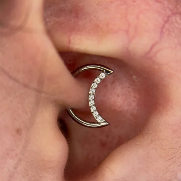 Femme avec Piercing Lune avec Zirconiums Clicker Titane 16G 10 mm au Daith (cartilage) Femme avec Piercing Lune avec Zirconiums Clicker Titane 16G 10 mm au Daith (cartilage).