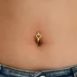 Femme avec Piercing Nombril Clicker Cœur Ajouré Pavé de Zirconiums.