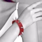 Femme avec Bracelet Clouté en Similicuir Rouge.