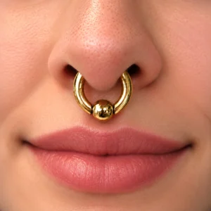 Femme avec Piercing Anneau CBR Doré Gros Calibre au Septum.